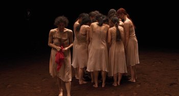 Movie still from “Pina” (2011), directed by Wim Wenders – A group of women standing in a circle on a stage; Wide shot, High angle