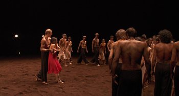 Movie still from “Pina” (2011), directed by Wim Wenders – A group of men and women standing in the dirt; Wide shot, High angle