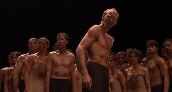 Movie still from “Pina” (2011), directed by Wim Wenders – A group of shirtless men standing next to each other; Medium shot, Low angle