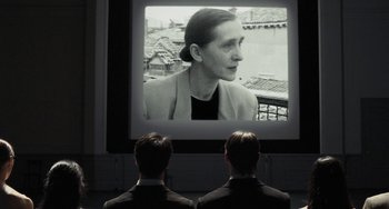 Movie still from “Pina” (2011), directed by Wim Wenders – Two men watching a movie on a projector screen; Medium shot, Over the shoulder angle