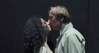 Movie still from “Pina” (2011), directed by Wim Wenders – A man and a woman kissing in front of a black background; Close Up shot, Low angle