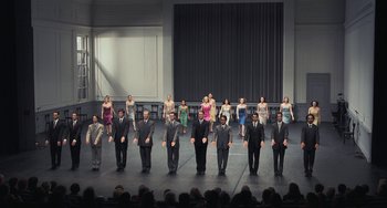 Movie still from “Pina” (2011), directed by Wim Wenders – A group of men and women standing on a stage; Wide shot, High angle