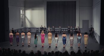 Movie still from “Pina” (2011), directed by Wim Wenders – A group of people standing on a stage in front of an audience; Wide shot, High angle