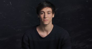 Movie still from “Pina” (2011), directed by Wim Wenders – A young man in a black shirt is posing for a picture; Close Up shot, High angle