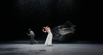 Movie still from “Pina” (2011), directed by Wim Wenders – A woman in a white dress and a man in a black shirt; Wide shot, High angle