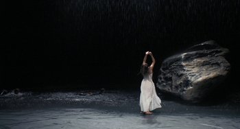 Movie still from “Pina” (2011), directed by Wim Wenders – A woman in a white dress standing in the middle of a river; Extreme Wide shot, High angle