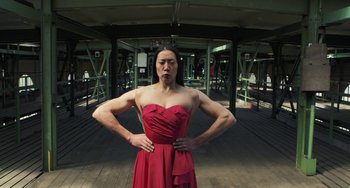 Movie still from “Pina” (2011), directed by Wim Wenders – A woman in a red dress posing for a picture; Medium shot, Low angle