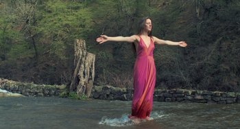 Movie still from “Pina” (2011), directed by Wim Wenders – A woman in a pink dress standing in the water; Wide shot, Low angle