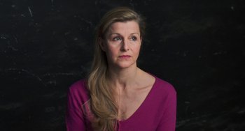 Movie still from “Pina” (2011), directed by Wim Wenders – A woman in a purple shirt is looking at the camera; Close Up shot, Low angle