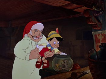 Movie still from “Pinocchio” (1940), directed by Jack Kinney – An old man and a young boy are looking at a fish bowl; Medium shot, High angle