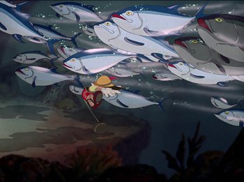 Movie still from “Pinocchio” (1940), directed by Jack Kinney – An underwater scene with a person swimming in the water and a bunch of fish swimming in the water; Wide shot, Overhead angle