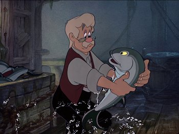 Movie still from “Pinocchio” (1940), directed by Jack Kinney – An old man holding a fish in his hands; Medium shot, Over the shoulder angle