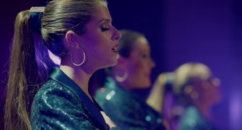 Movie still from “Pitch Perfect 2” (2015), directed by Elizabeth Banks – Two women are singing in front of a purple background; Close Up shot, Over the shoulder angle