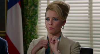 Movie still from “Pitch Perfect 2” (2015), directed by Elizabeth Banks – A woman in a white jacket is adjusting her neck tie; Close Up shot, Over the shoulder angle