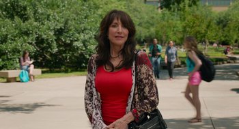 Movie still from “Pitch Perfect 2” (2015), directed by Elizabeth Banks – A woman in a red top and a black purse; Medium shot, Over the shoulder angle