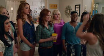 Movie still from “Pitch Perfect 2” (2015), directed by Elizabeth Banks – A group of women standing next to each other in a room; Medium shot, Over the shoulder angle