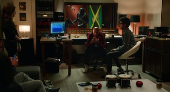 Movie still from “Pitch Perfect 2” (2015), directed by Elizabeth Banks – Two men sitting in front of computer screens in a recording studio; Wide shot, Over the shoulder angle