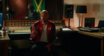 Movie still from “Pitch Perfect 2” (2015), directed by Elizabeth Banks – A man sitting in front of a sound board; Medium shot, Over the shoulder angle