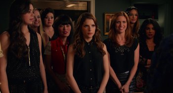 Movie still from “Pitch Perfect 2” (2015), directed by Elizabeth Banks – A group of women standing next to each other in a room; Medium shot, Over the shoulder angle