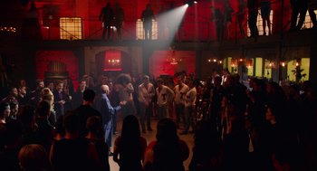 Movie still from “Pitch Perfect 2” (2015), directed by Elizabeth Banks – A group of people standing in a room with guitars; Extreme Wide shot, High angle