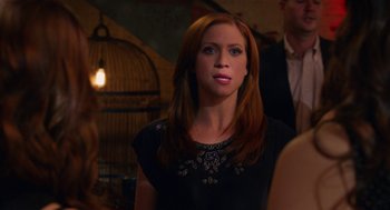 Movie still from “Pitch Perfect 2” (2015), directed by Elizabeth Banks – A woman in a black dress standing in front of a bird cage; Close Up shot, Over the shoulder angle