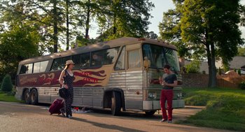 Movie still from “Pitch Perfect 2” (2015), directed by Elizabeth Banks – A man and a woman standing in front of a bus; Wide shot, Low angle