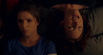 Movie still from “Pitch Perfect 2” (2015), directed by Elizabeth Banks – Two young people laying on the ground in a dark room; Close Up shot, Overhead angle