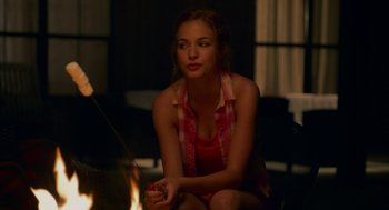 Movie still from “Pitch Perfect 2” (2015), directed by Elizabeth Banks – A woman sitting in front of an open fire; Medium shot, Over the shoulder angle