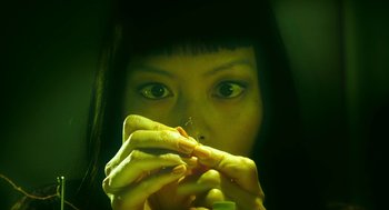 Movie still from “Pitch Perfect 3” (2017), directed by Trish Sie – A woman holding a piece of food in front of her face; Extreme Close Up shot, Overhead angle