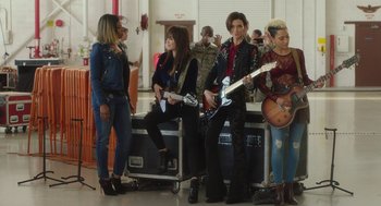 Movie still from “Pitch Perfect 3” (2017), directed by Trish Sie – A group of people that are sitting down with guitars; Wide shot, High angle