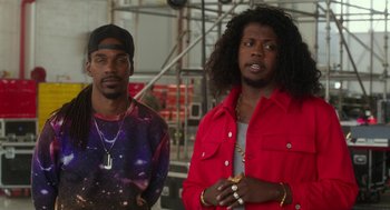 Movie still from “Pitch Perfect 3” (2017), directed by Trish Sie – A couple of men standing next to each other; Medium shot, Over the shoulder angle