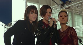 Movie still from “Pitch Perfect 3” (2017), directed by Trish Sie – A group of women standing next to each other holding a microphone; Medium shot, Low angle