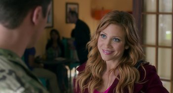 Movie still from “Pitch Perfect 3” (2017), directed by Trish Sie – A beautiful woman with blue eyes smiling at the camera; Close Up shot, Over the shoulder angle