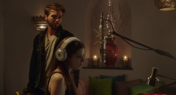 Movie still from “Pitch Perfect 3” (2017), directed by Trish Sie – A man and a woman listening to headphones; Medium shot, Over the shoulder angle
