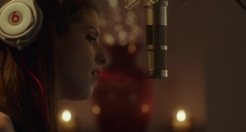 Movie still from “Pitch Perfect 3” (2017), directed by Trish Sie – A woman is standing in front of a microphone; Close Up shot, Over the shoulder angle
