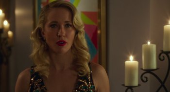 Movie still from “Pitch Perfect 3” (2017), directed by Trish Sie – A woman with blonde curly hair wearing a gold dress; Close Up shot, Over the shoulder angle