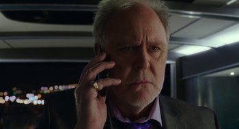 Movie still from “Pitch Perfect 3” (2017), directed by Trish Sie – An older man in a business suit talking on a cell phone; Close Up shot, Low angle