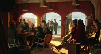 Movie still from “Pitch Perfect 3” (2017), directed by Trish Sie – A group of people sitting at tables in a restaurant; Wide shot, Over the shoulder angle