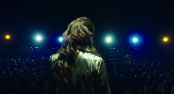 Movie still from “Pitch Perfect 3” (2017), directed by Trish Sie – A woman standing in front of a crowd of people; Medium shot, High angle