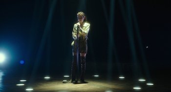Movie still from “Pitch Perfect 3” (2017), directed by Trish Sie – A woman standing on a stage holding a microphone; Wide shot, High angle