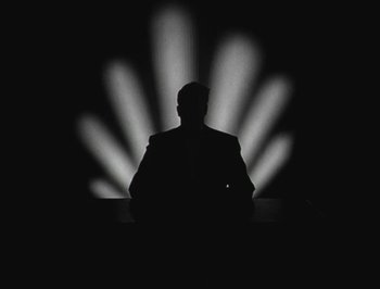 A man sitting in front of a wall of light