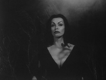 A black and white photo of a woman in a black dress