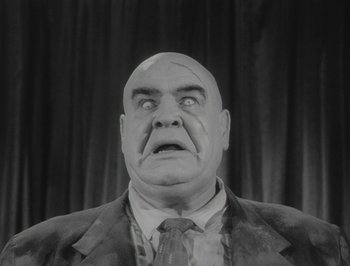 A man with a bald head wearing a suit and tie