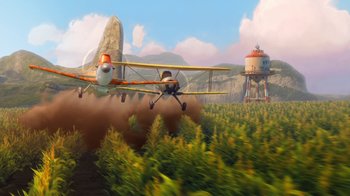 Movie still from “Planes” (2013), directed by Klay Hall – A plane flying over a field with smoke coming out of the bottom; Extreme Wide shot, Low angle