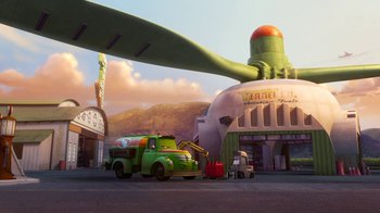 Movie still from “Planes” (2013), directed by Klay Hall – An old green truck is parked on the side of the road; Extreme Wide shot, Low angle