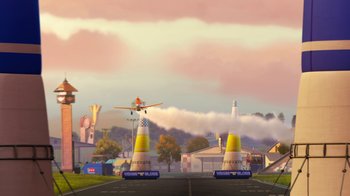Movie still from “Planes” (2013), directed by Klay Hall – An airplane is flying low to the ground near two cones; Extreme Wide shot, Low angle