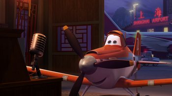 Movie still from “Planes” (2013), directed by Klay Hall – An airplane is sitting in the middle of a room with a microphone; Wide shot, Low angle
