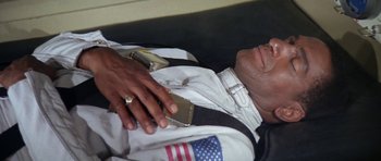 Movie still from “Planet of the Apes” (1968), directed by Franklin J. Schaffner – A man in a white shirt is holding a cell phone; Close Up shot, Overhead angle