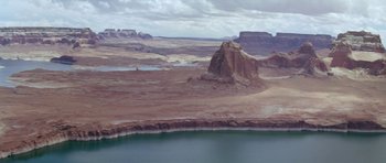 Movie still from “Planet of the Apes” (1968), directed by Franklin J. Schaffner – A view of a desert landscape with a body of water in the foreground; Extreme Wide shot, High angle