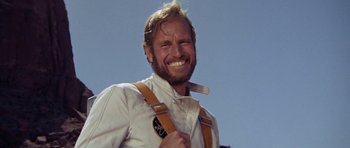 Movie still from “Planet of the Apes” (1968), directed by Franklin J. Schaffner – A man wearing suspenders holding a tooth brush in his mouth; Close Up shot, Low angle